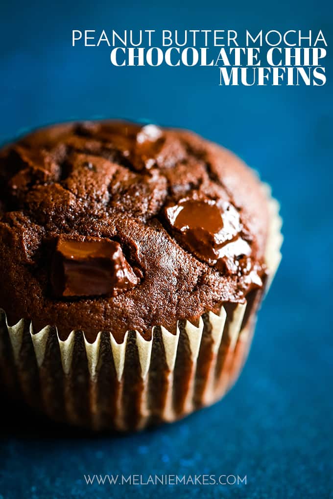 An up close shot of a Peanut Butter Mocha Chocolate Chip Muffin rests on a blue surface.