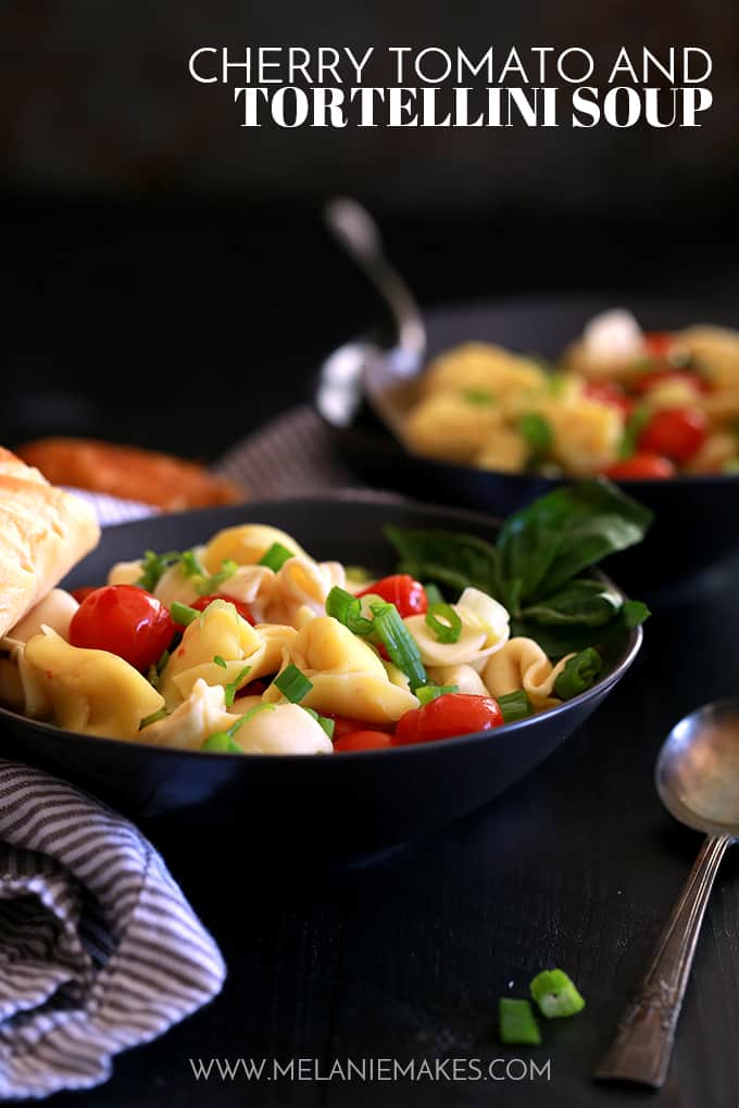 Two bowls of Cherry Tomato and Tortellini Soup garnished with green onions.