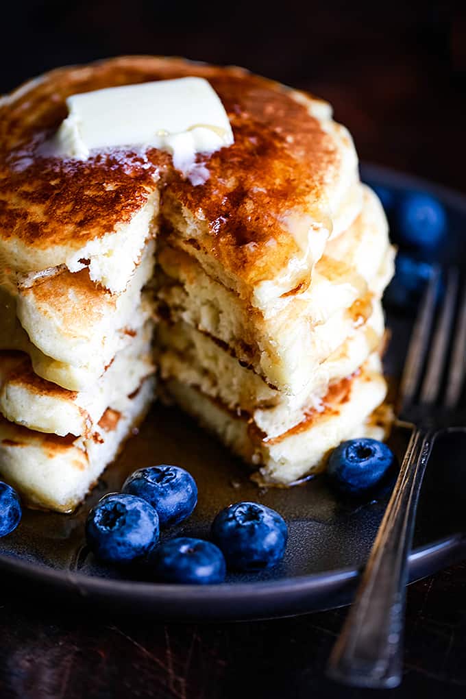 A stack of the Best Buttermilk Pancakes with a wedge removed.