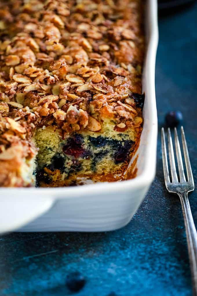 A baking dish of Blueberry Lemon Almond Coffee Cake with a slice removed.