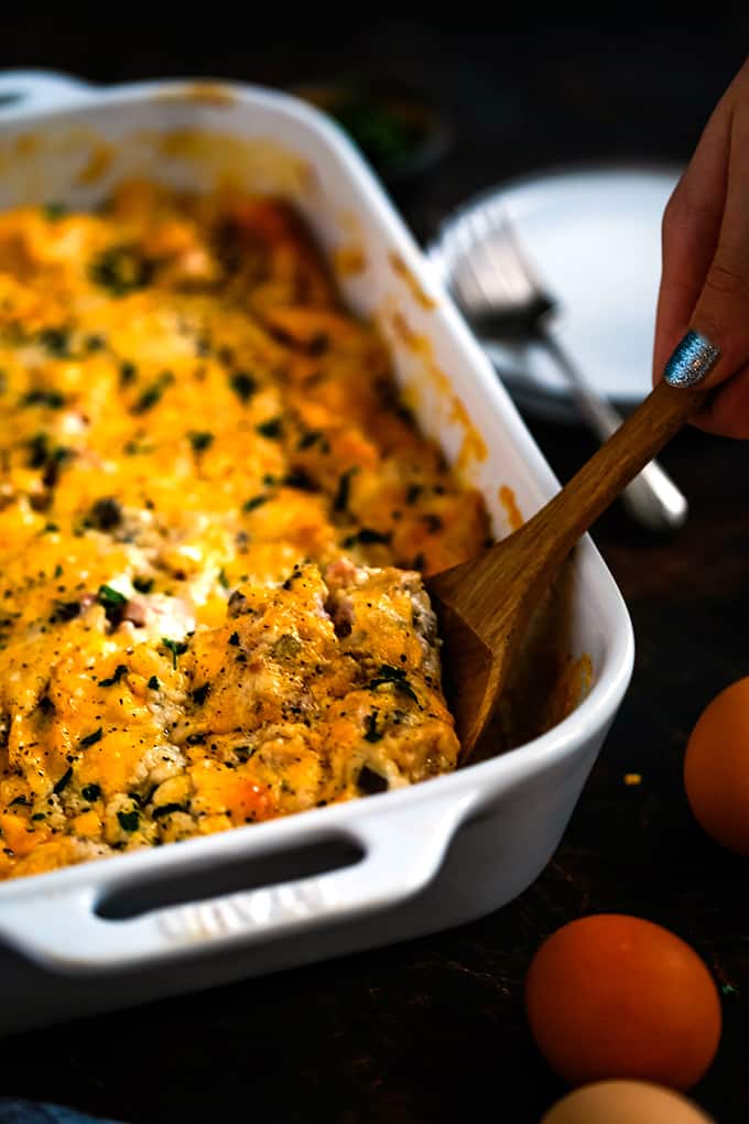 A spatula removing a piece of Bridge Brunch Casserole from a baking dish.