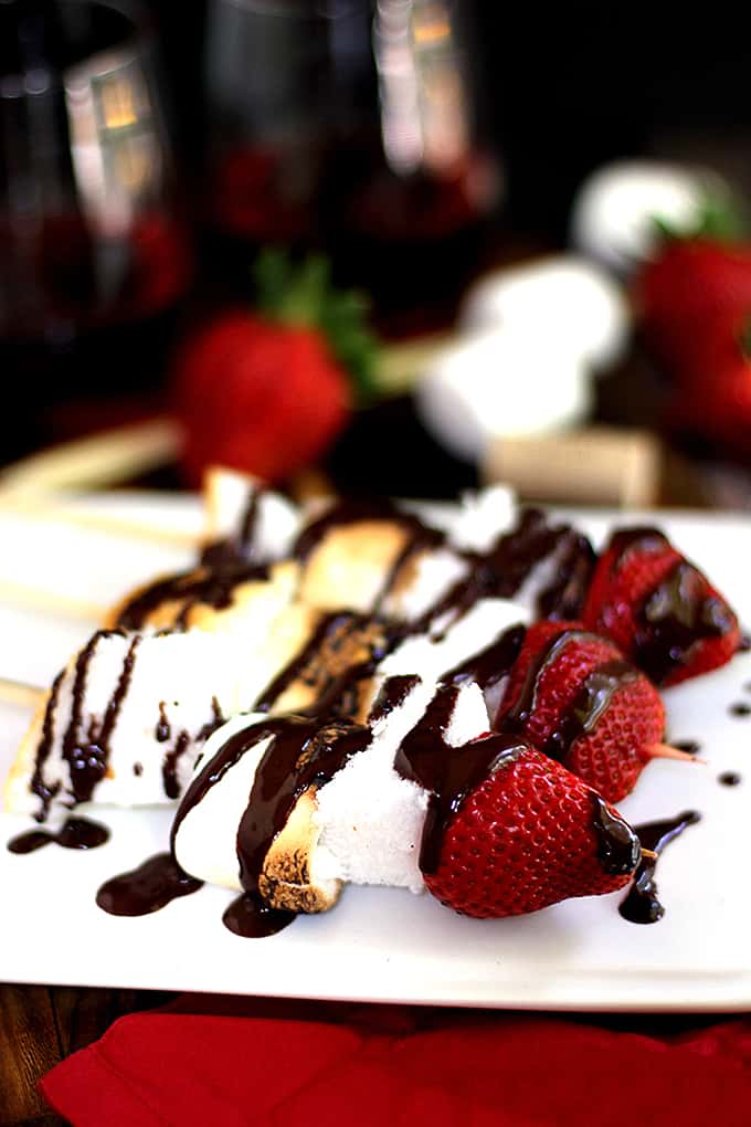 These Angel Food Cake S'mores Skewers are the perfect adult spin on a childhood favorite. A perfectly toasted marshmallow is skewered between two pieces of angel food cake and topped with a strawberry before being drizzled with a luscious dark chocolate sauce spiked with wine.