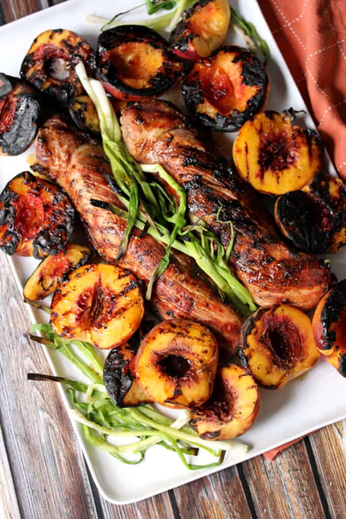 This Honey Ginger Glazed Grilled Pork Tenderloin and Peaches is the perfect sweet and savory dinner combination. A sticky, sweet honey glaze spiked with fresh ginger is drizzled over perfectly grilled pork tenderloin and charred green onions and peaches. A complete meal made entirely on the grill!