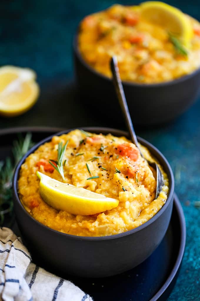 A bowl of Slow Cooker Lemon Rosemary Lentil Soup with a spoon.