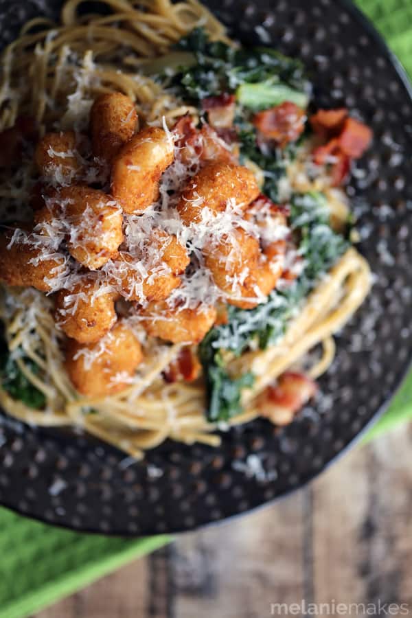 This eight ingredient Shrimp, Bacon and Kale Parmesan Pasta makes any dinner special and comes together in just 30 minutes. Your favorite pasta is dressed in balsamic vinegar and olive oil and studded with sauteed sliced onions and chopped kale. Everyone then gets the opportunity to top their bowls with popcorn shrimp, crispy bacon and a shower of Parmesan cheese.