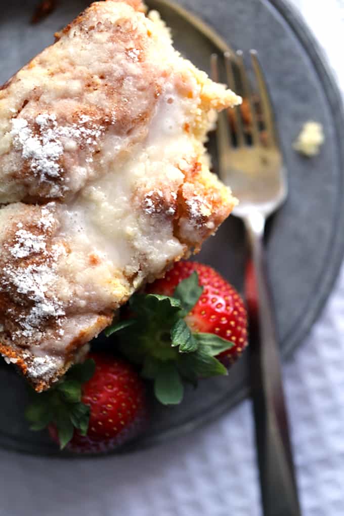 This Strawberries and Cream Coffee Cake will have your family rolling out of their beds and making a beeline for the kitchen in record time. A thick swirl of cream cheese and strawberry jam is sandwiched between two layers of light as air coffee cake. This breakfast treat is then topped with a sugar and butter topping before being baked and then drizzled with a powdered sugar glaze. 