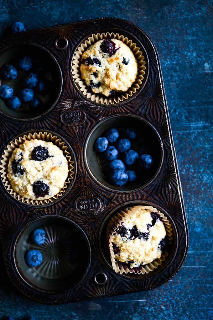 With a stir of a spoon and just four ingredients, you’ll be ready to put these Yogurt Blueberry Oatmeal Muffins in the oven before it’s even preheated! #blueberry #yogurt #oatmeal #muffins #breakfast #brunch Yogurt Blueberry Oatmeal Muffins sit in a muffin tin.