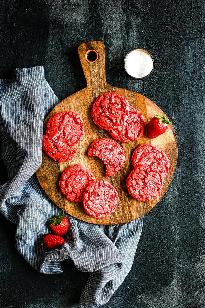 Strawberry Sugar Cookies on a wood platter with a striped napkin next to it.