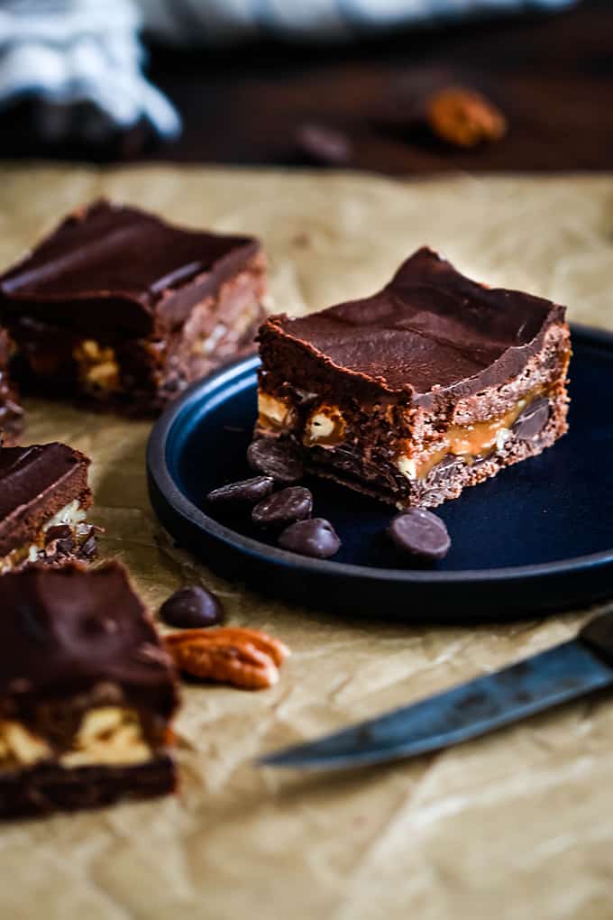 An Easy Snickers Brownie on a black plate.