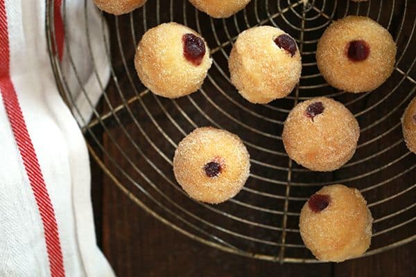 These baked Raspberry Filled Caramel Donut Holes are the perfect weekend treat and easy to make at home.  Caramel flavored donut holes are filled with raspberry preserves before being brushed with butter and rolled in caramel sugar.