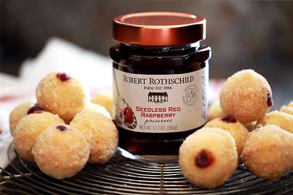 These baked Raspberry Filled Caramel Donut Holes are the perfect weekend treat and easy to make at home.  Caramel flavored donut holes are filled with raspberry preserves before being brushed with butter and rolled in caramel sugar.