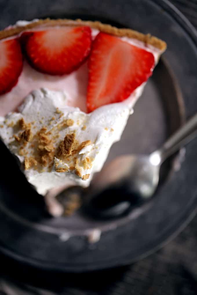 This Strawberry Cheesecake Ice Cream Pie takes just 10 minutes and five ingredients to prepare! Strawberry cheesecake ice cream is swirled together with cheesecake pudding and whipped topping before being poured into a graham cracker pie shell. It's then frozen before being garnished with slices of juicy strawberries, a pillowy cloud of additional whipped topping and a dusting of graham cracker crumbs.