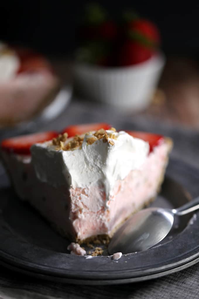 This Strawberry Cheesecake Ice Cream Pie takes just 10 minutes and five ingredients to prepare! Strawberry cheesecake ice cream is swirled together with cheesecake pudding and whipped topping before being poured into a graham cracker pie shell. It's then frozen before being garnished with slices of juicy strawberries, a pillowy cloud of additional whipped topping and a dusting of graham cracker crumbs.