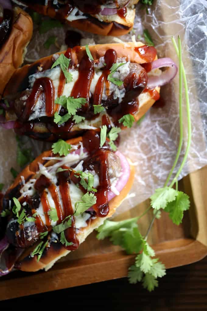 These Barbecue Pizza Bratwursts take all the flavors of your favorite pizza and reinvents them as toppings for your brat. A toasted bun is layered with grilled red onions and bratwurst before being drizzled with barbecue sauce, covered in melted mozzarella cheese and sprinkled with cilantro. 