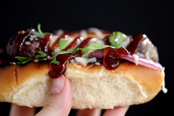 These Barbecue Pizza Bratwursts take all the flavors of your favorite pizza and reinvents them as toppings for your brat. A toasted bun is layered with grilled red onions and bratwurst before being drizzled with barbecue sauce, covered in melted mozzarella cheese and sprinkled with cilantro. 