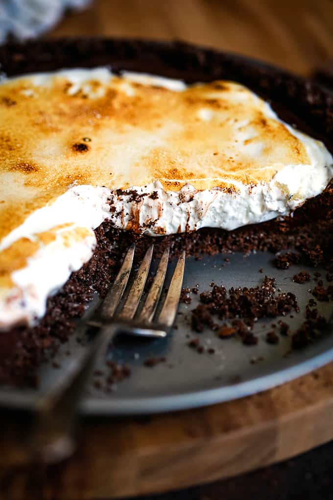 A Double Chocolate No Bake S'mores Pie with slices removed and a fork sitting in the pie plate.