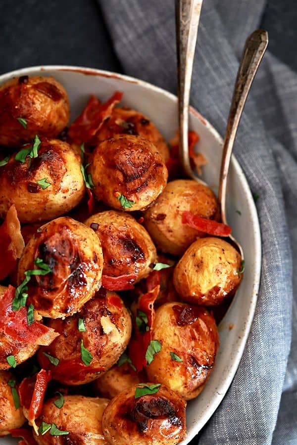 These Roasted Potatoes with Figs and Prosciutto take just 10 minutes to prepare and are a definite contender for easiest side dish ever! Buttery Yukon Gold potatoes are tossed in yogurt, figs, garlic and red pepper flakes before being showered with crisp sheets of prosciutto and ribbons of fresh basil. 