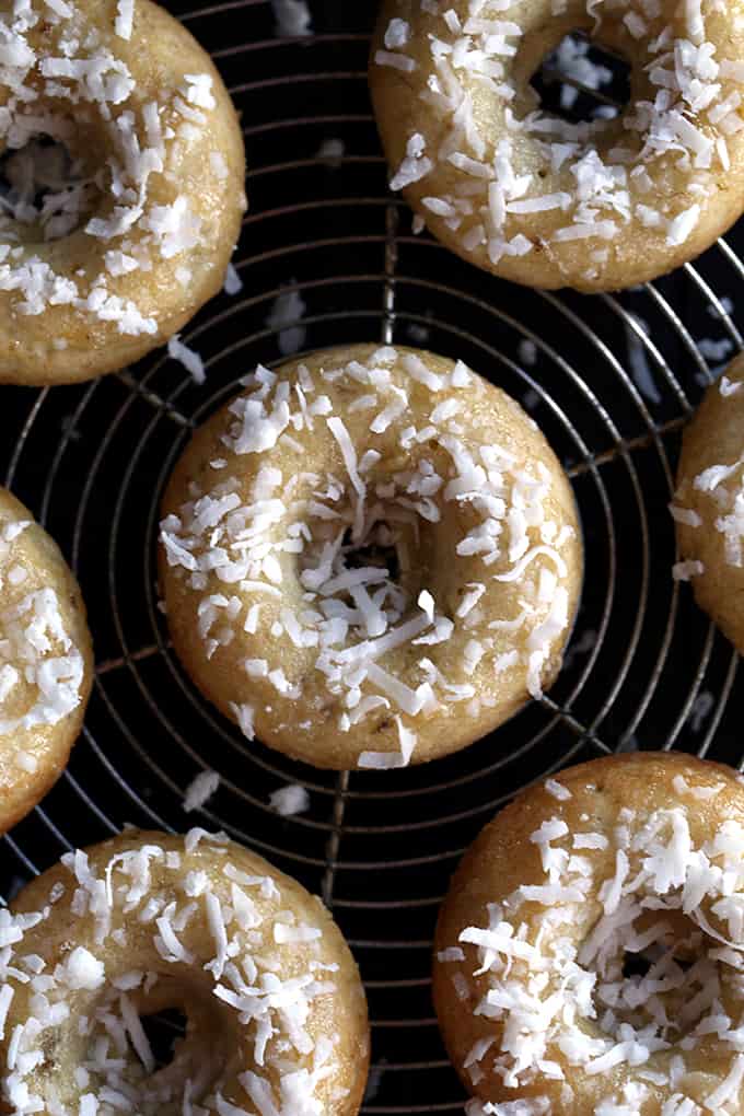 These Coconut Banana Bread Donuts are destined to transport you to your happy place without getting up from your breakfast table. A banana bread batter spiked with coconut is baked to donut perfection before being drizzled with a banana glaze and sprinkled with additional coconut. 