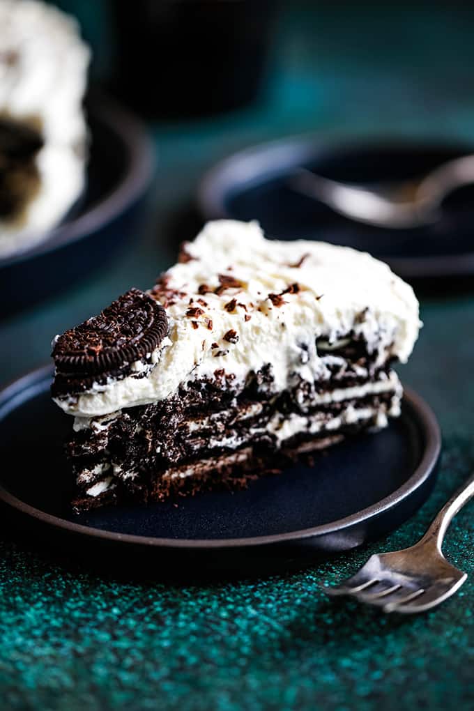 A slice of Irish Cream Oreo Icebox Cake sits on a black plate.
