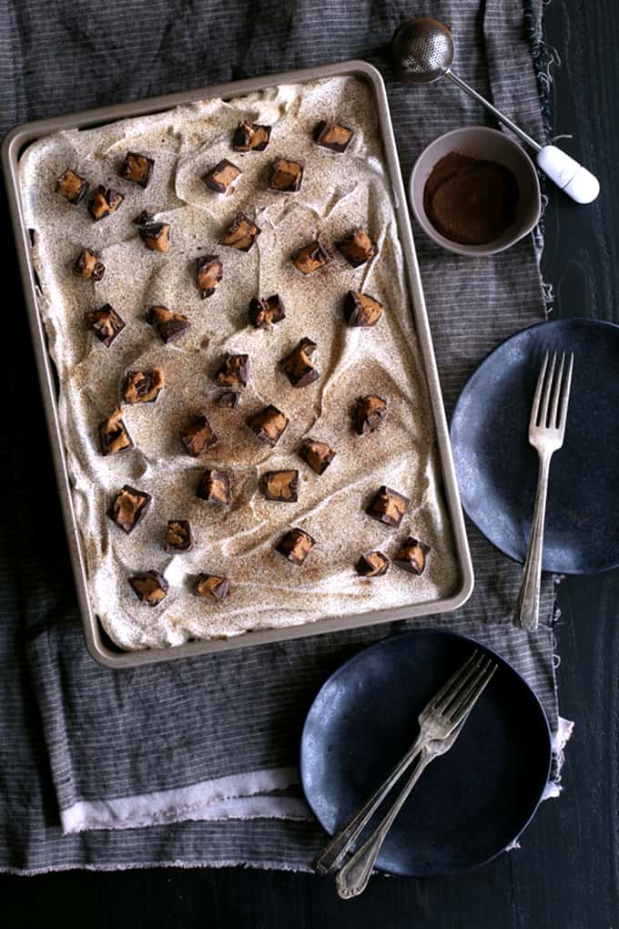 This Peanut Butter Mocha Poke cake is so decadent, so rich, and so incredibly easy! A mocha chocolate cake is flooded with peanut butter chocolate pudding before being topped with layers of mocha ganache, whipped topping and dark chocolate peanut butter cups before being dusted with espresso powder.