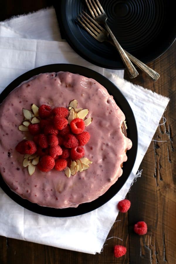 You won't believe how incredibly simple this Raspberry Almond Cheesecake Cake is to create. Layers of cake studded with fresh raspberries alternate with layers of raspberry almond cheesecake to create this amazingly delicious dessert. A raspberry almond glaze, more fresh raspberries and sliced almonds top this showstopper that's sure to impress whoever is lucky enough to snag a slice.