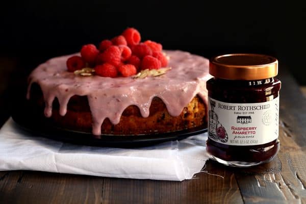 You won't believe how incredibly simple this Raspberry Almond Cheesecake Cake is to create. Layers of cake studded with fresh raspberries alternate with layers of raspberry almond cheesecake to create this amazingly delicious dessert. A raspberry almond glaze, more fresh raspberries and sliced almonds top this showstopper that's sure to impress whoever is lucky enough to snag a slice.