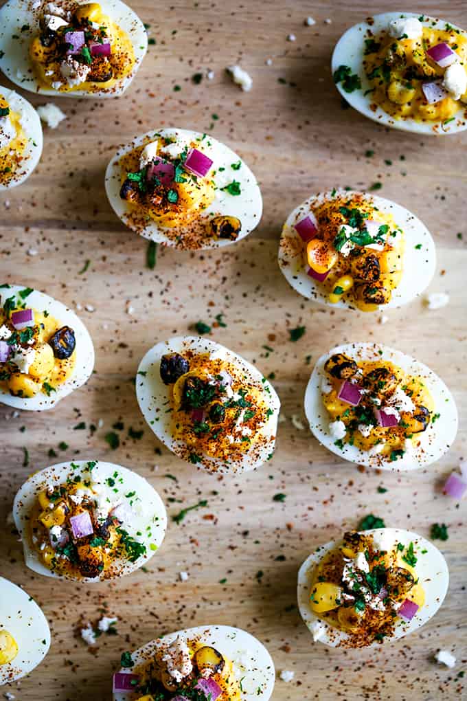 Mexican Street Corn Deviled Eggs on a wooden surface.