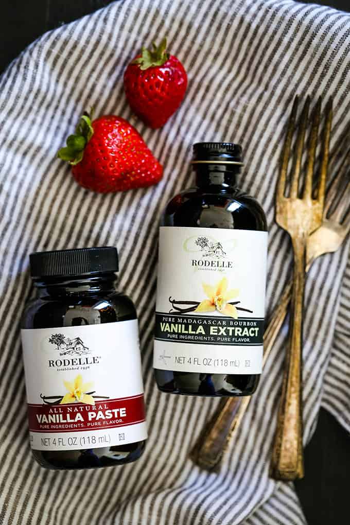 Jars of Rodelle Vanilla Paste and Vanilla Extract on a striped napkin.