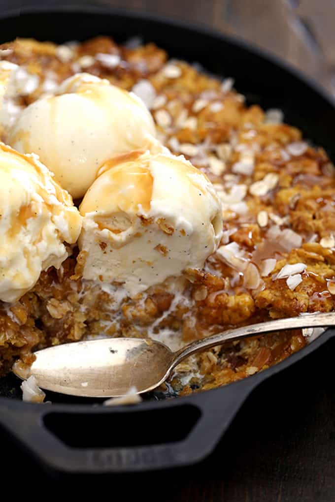 This one dish Coconut Caramel Pumpkin Oatmeal Skillet Cookie takes just 10 minutes to prepare and is the definition of a perfect fall dessert. Coconut flakes and rolled oats are stirred into a pumpkin oatmeal cookie base and baked in the same pan that it was mixed in. It's then topped with additional coconut, oats, caramel sauce and ice cream to create the seasonal dessert of your dreams.