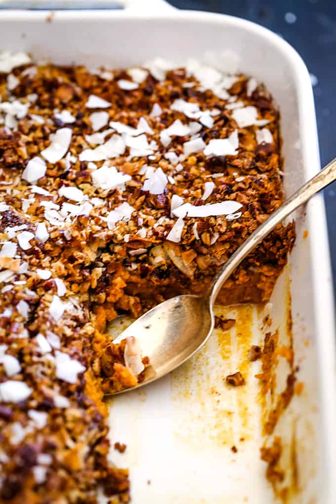 A white baking dish of German Chocolate Upside Down Pumpkin Pie with slices removed.