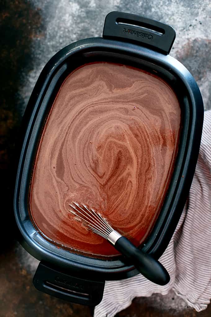 This Slow Cooker Almond Joy Hot Chocolate takes just five minutes to prepare, yet makes enough to wow a crowd!  Whole milk, heavy cream, cocoa and almond extract are whisked together to form this decadently delicious treat.  Garnished with whipped topping, sliced almonds and coconut flakes, this hot chocolate is easily the best around.