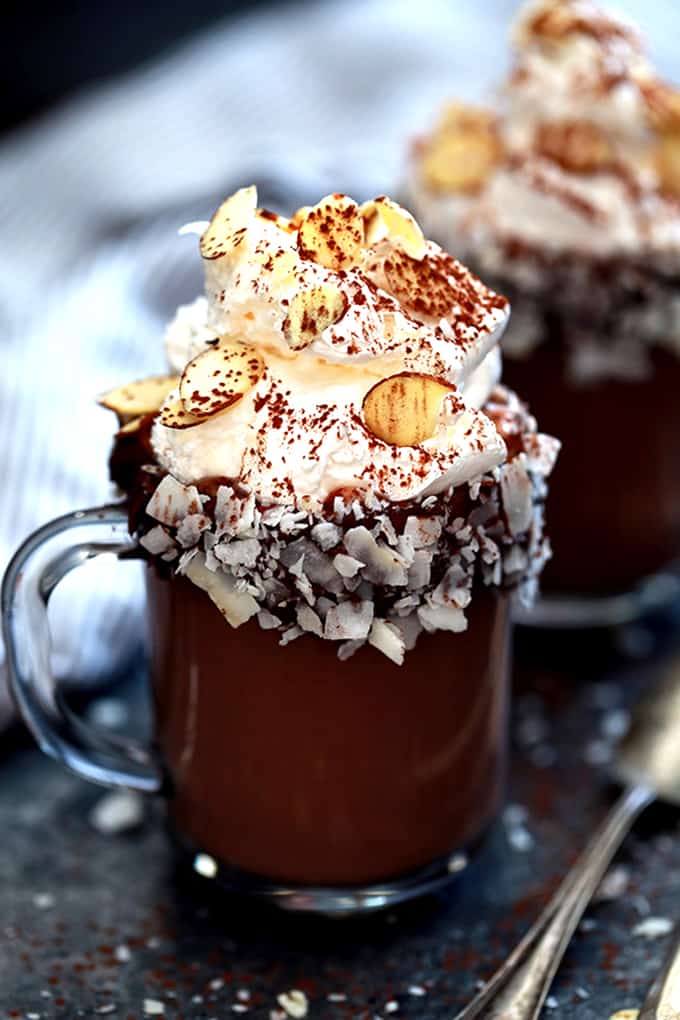 This Slow Cooker Almond Joy Hot Chocolate takes just five minutes to prepare, yet makes enough to wow a crowd!  Whole milk, heavy cream, cocoa and almond extract are whisked together to form this decadently delicious treat.  Garnished with whipped topping, sliced almonds and coconut flakes, this hot chocolate is easily the best around.