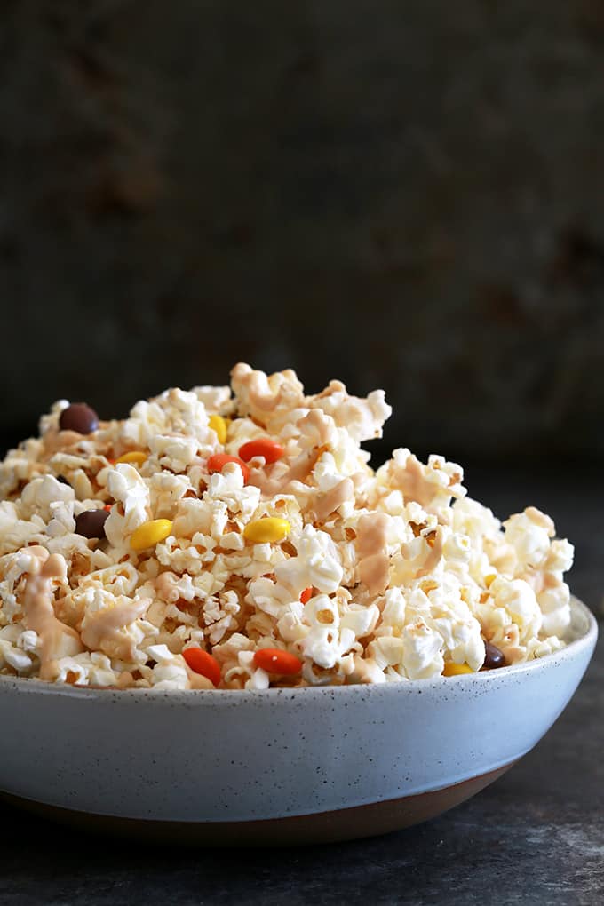 This four ingredient White Chocolate Peanut Butter Popcorn is a perfect snack choice, no matter the occasion. Salty popcorn is drizzled with a peanut butter white chocolate and studded with Reese's Pieces candy. The perfect sweet and salty combination!