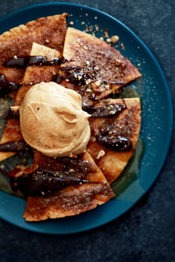These Turtle Churro Nachos are the perfect dessert to feed a crowd. Homemade cinnamon and sugar speckled tortilla chips are drizzled with caramel sauce and chocolate ganache before being crowned with a dollop of caramel cream cheese. They're then sprinkled with chopped pecans and additional cinnamon sugar. 