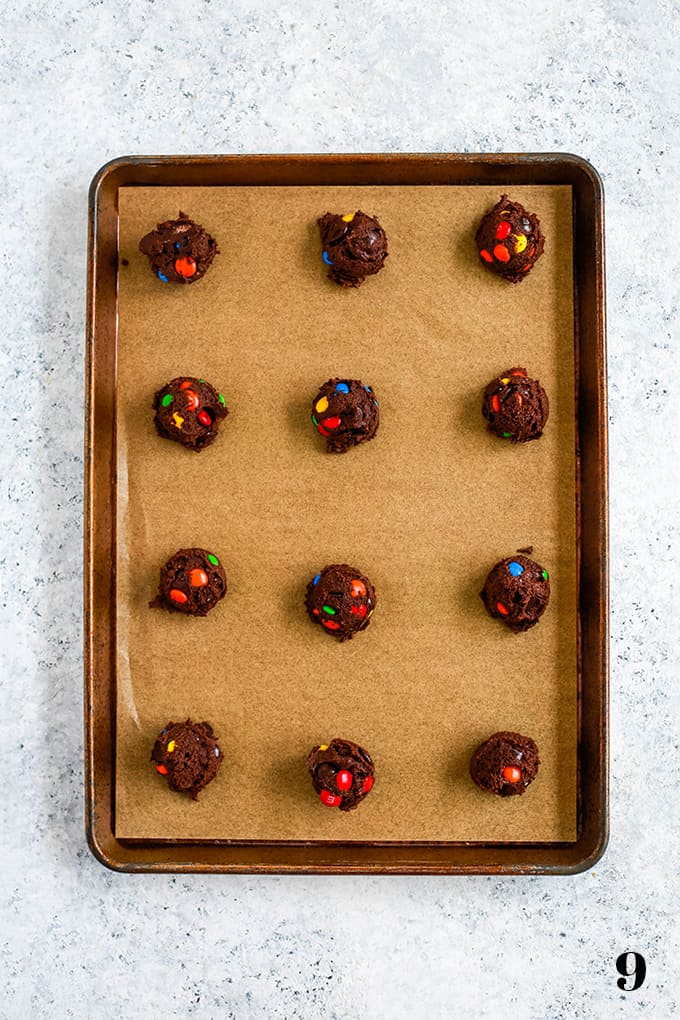 A cocoa infused chocolate chip cookie dough batter is bedazzled with dark chocolate chips and M&Ms candy to make these amazing Double Chocolate M&M Cookies. #cookies #candy #desserts #chocolate #easyrecipe How to prepare Double Chocolate M&M Cookies, step 9.