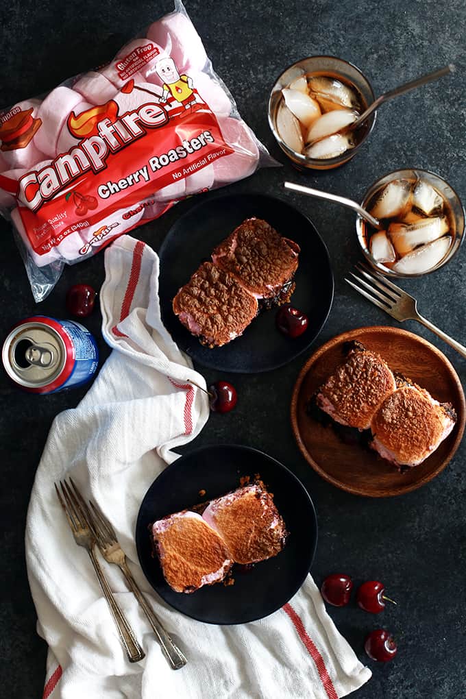 These Cherry Cola S'mores Brownies are the perfect dessert mashup. A buttery, graham cracker base is topped with a cherry cola spiked brownie batter, dark chocolate candy bars and maraschino cherries before being topped with a pillowy layer of cherry flavored marshmallows. They're pretty much heaven in brownie form!