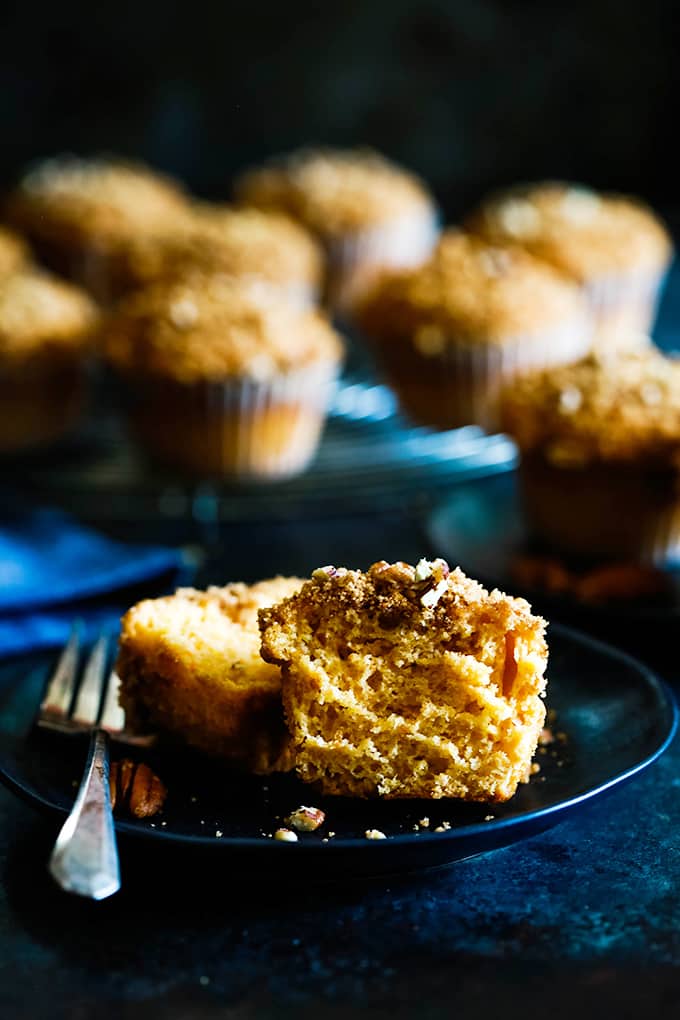 A split Butterscotch Muffin sits on a black plate with a fork.