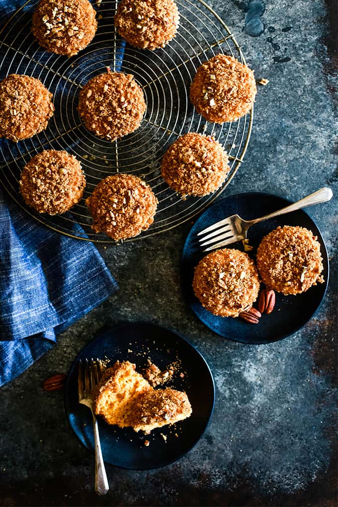 An overhead view of two plates and a round cooling rack with Butterscotch Muffins with Brown Sugar Pecan Streusel.