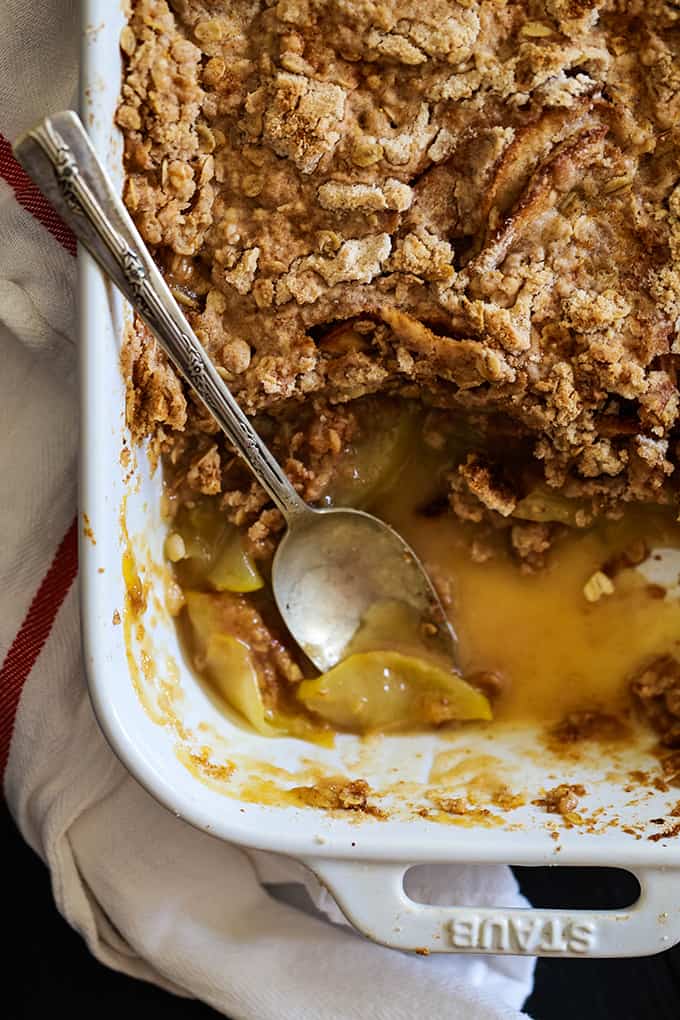 An overhead view of a Snickerdoodle Apple Crisp with a serving removed and a silver spoon.