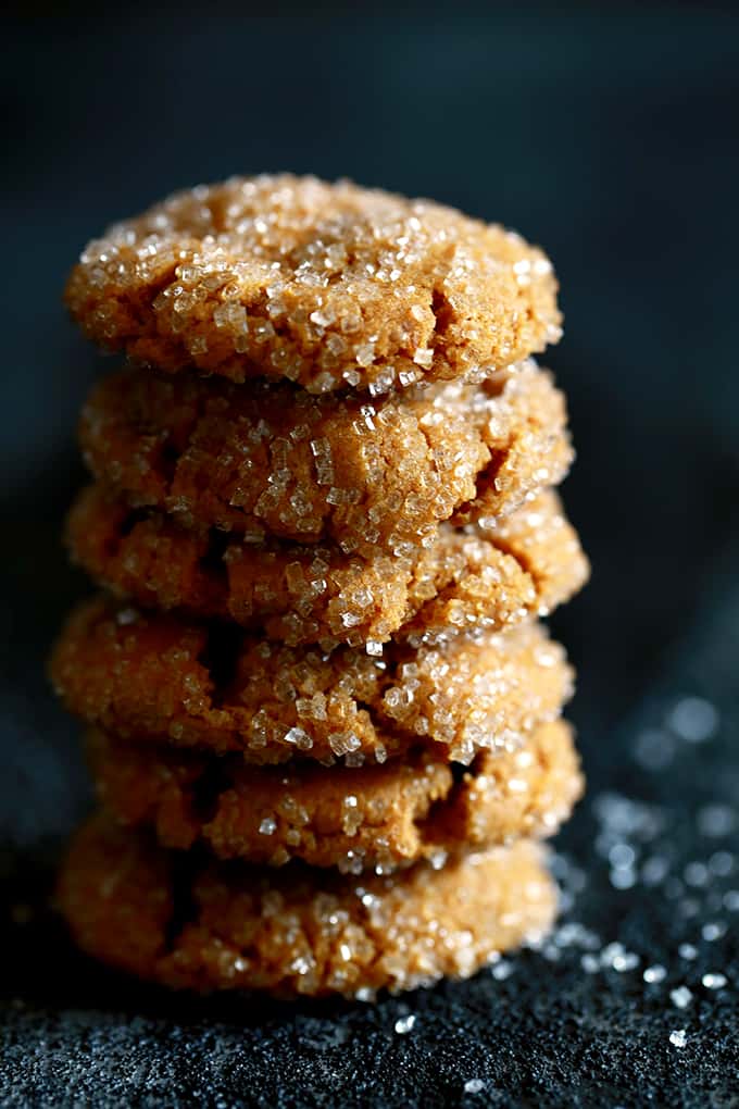 These eight ingredient Soft and Chewy Pumpkin Ginger Cookies are perfect any time of year but are destined to be an autumn cookie all-star. Pumpkin, molasses, cinnamon and ginger bring the warmth and expected fall flavors to these pillowy cookies. #pumpkin #ginger #cookies #autumn #fallrecipes #easydesserts A stack of Soft and Chewy Pumpkin Ginger Cookies sit on a black background.