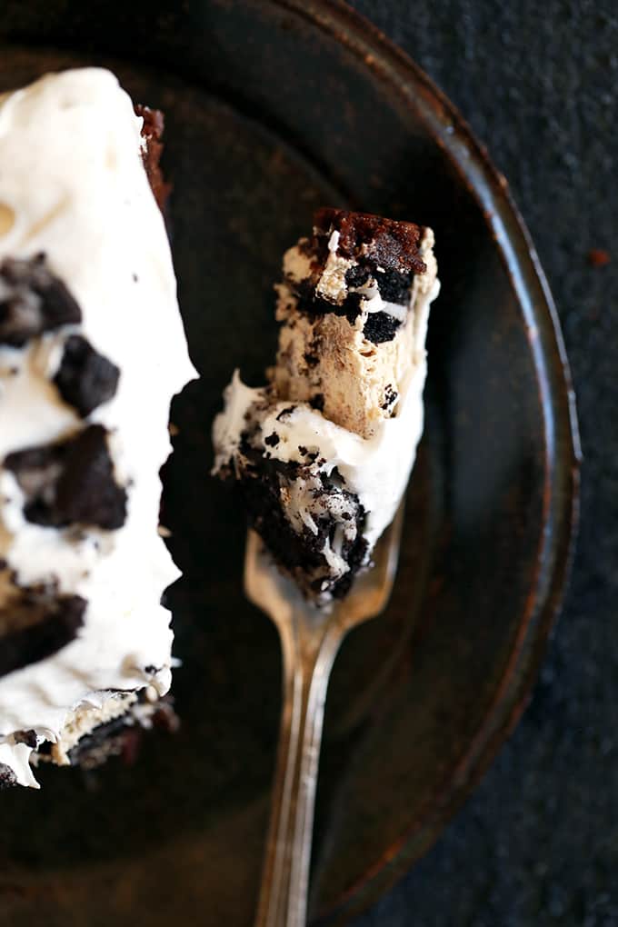 This Coffee Cookies and Cream Cheesecake Brownie Cake is like enjoying five of your favorite desserts all at once. A brownie base is topped with a mocha infused cheesecake studded with Oreos before being topped by a cloud of whipped topping and even more crushed cookies. Basically each and every bite is like pure and absolute heaven. This Coffee Cookies and Cream Cheesecake Brownie Cake is like enjoying five of your favorite desserts all at once. A brownie base is topped with a mocha infused cheesecake studded with Oreos before being topped by a cloud of whipped topping and even more crushed cookies. Basically each and every bite is like pure and absolute heaven.