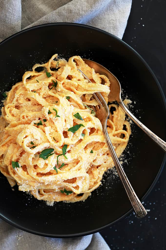 This eight ingredient Skinny Pumpkin Alfredo Sauce uses common pantry and fridge ingredients which means you can enjoy it any day of the week without making a special trip to the grocery store.  Garlic, Parmesan cheese, chicken broth and Greek yogurt are thickened into an amazing creamy sauce.  Once you stir in pumpkin puree and a sprinkle of ground nutmeg, well, an autumn pasta favorite is born.
