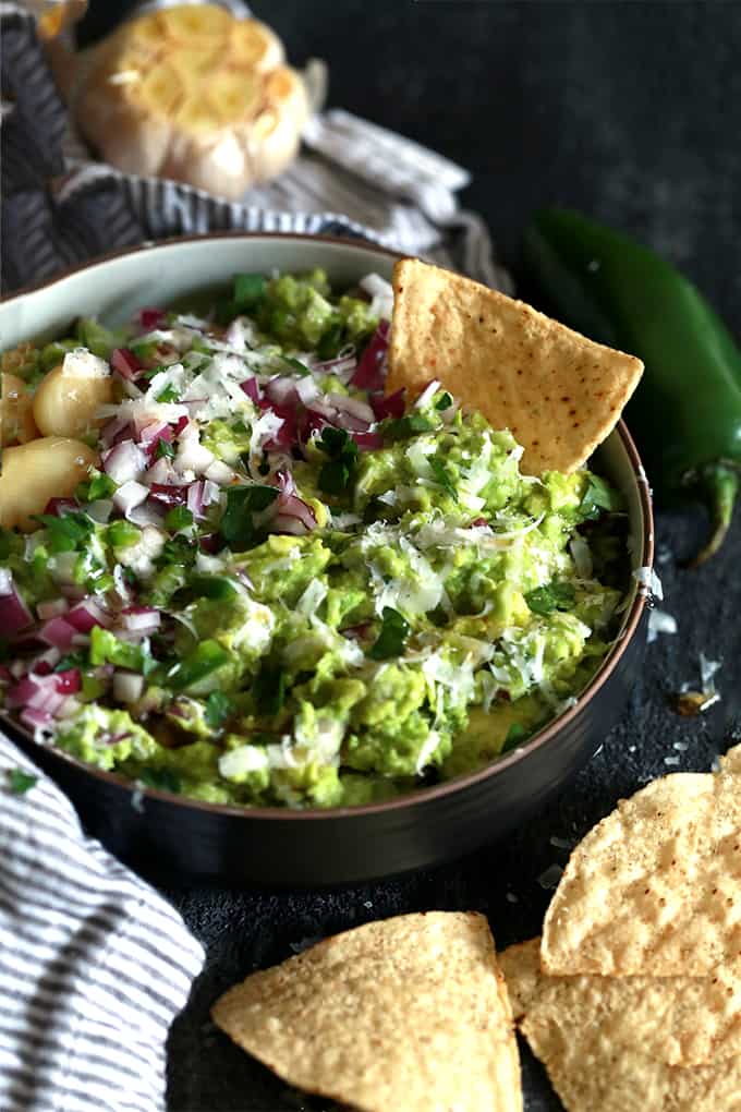 This Pecorino Guacamole begins with roasted garlic, red onion and jalapeño that are mashed with fresh avocado before being showered with Pecorino Romano cheese. This easy guacamole recipe is then seasoned with salt and pepper and garnished with additional onion, jalapeño, parsley and a drizzle of agave nectar. This Pecorino Guacamole begins with roasted garlic, red onion and jalapeño that are mashed with fresh avocado before being showered with Pecorino Romano cheese. This easy guacamole recipe is then seasoned with salt and pepper and garnished with additional onion, jalapeño, parsley and a drizzle of agave nectar.