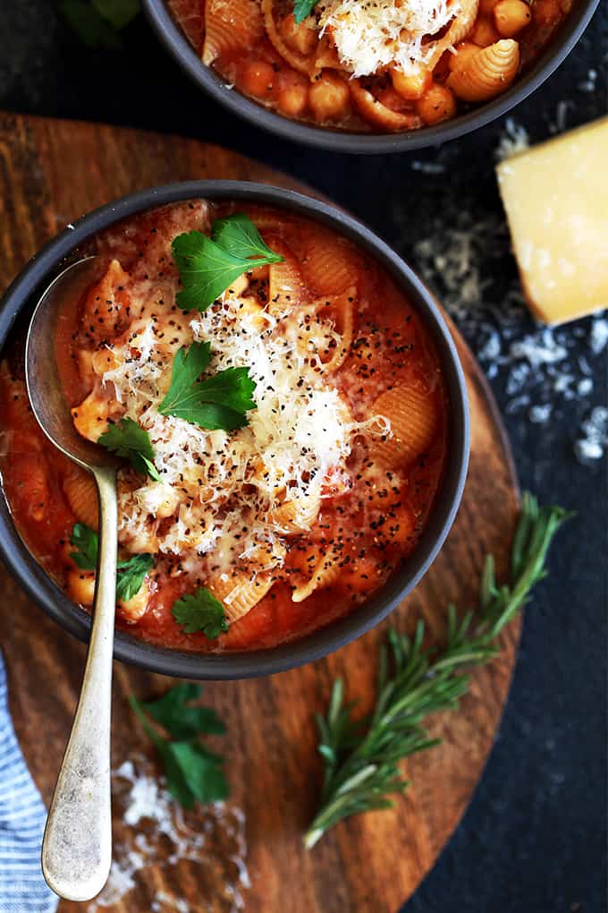 A bowl of Chickpea and Pasta Soup sitting on a wooden tray.