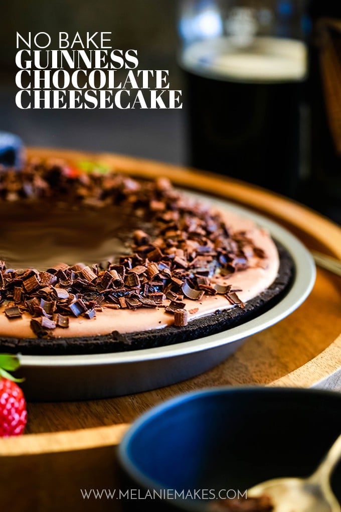 A No Bake Guinness Chocolate Cheesecake rests on a wooden tray.