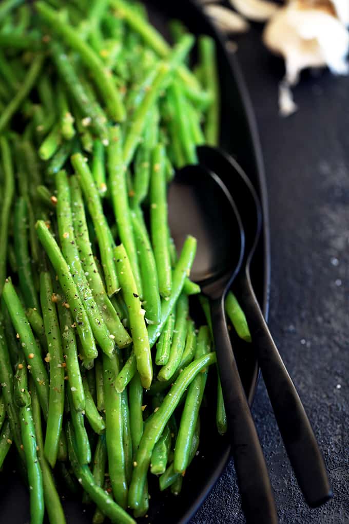 These Garlic Butter Green Beans are the perfect ace to have up your sleeve to serve with just about anything.  Using just three ingredients and taking only 20 minutes from start to finish, fresh green beans are trimmed and simmered until crisp tender before being bathed in butter and fresh garlic and seasoned with salt and pepper. #sidedish #greenbeans #garlic #butter