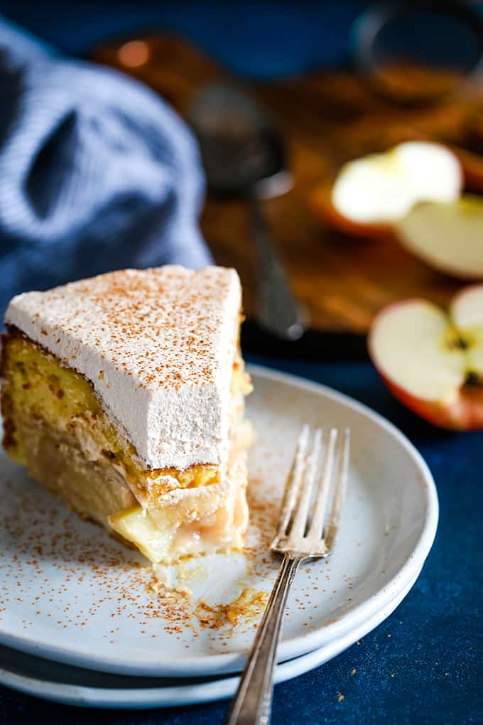 A slice of Apple Piecaken served on a white plate with a bite removed.