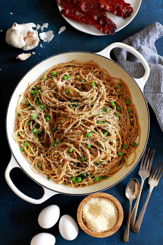 Pasta for breakfast?  This Breakfast Carbonara is absolutely a real and delicious thing!  Al dente spaghetti is tossed with minced garlic and peas before being swirled together with beaten eggs that are cooked by the heat from the hot pasta before being showered with grated Parmesan cheese and parsley as well as crumbled strips of bacon.   