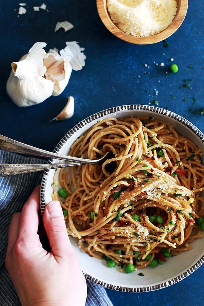 Pasta for breakfast?  This Breakfast Carbonara is absolutely a real and delicious thing!  Al dente spaghetti is tossed with minced garlic and peas before being swirled together with beaten eggs that are cooked by the heat from the hot pasta before being showered with grated Parmesan cheese and parsley as well as crumbled strips of bacon.   