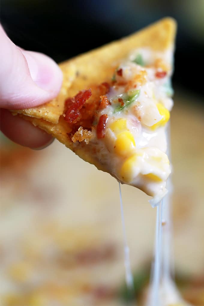 This Sweet Corn Queso with Pepperoni Crumbs literally comes together by just stirring ingredients together with a spoon in a cast iron skillet.  Red onion, garlic, jalapeño and corn are stirred into Monterey Jack cheese to create this incredible queso that's garnished with the most insanely delicious pepperoni crumbs, cilantro and jalapeños.